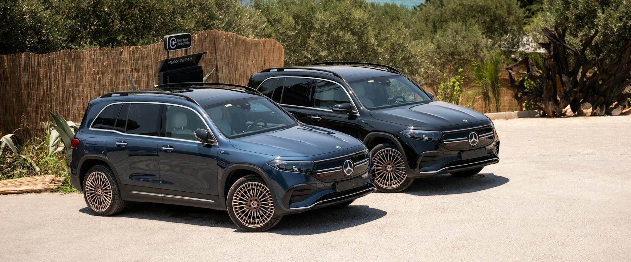 Two Mercedes EQB SUVs parked by the sunlit coast in İzmir, Türkiye.